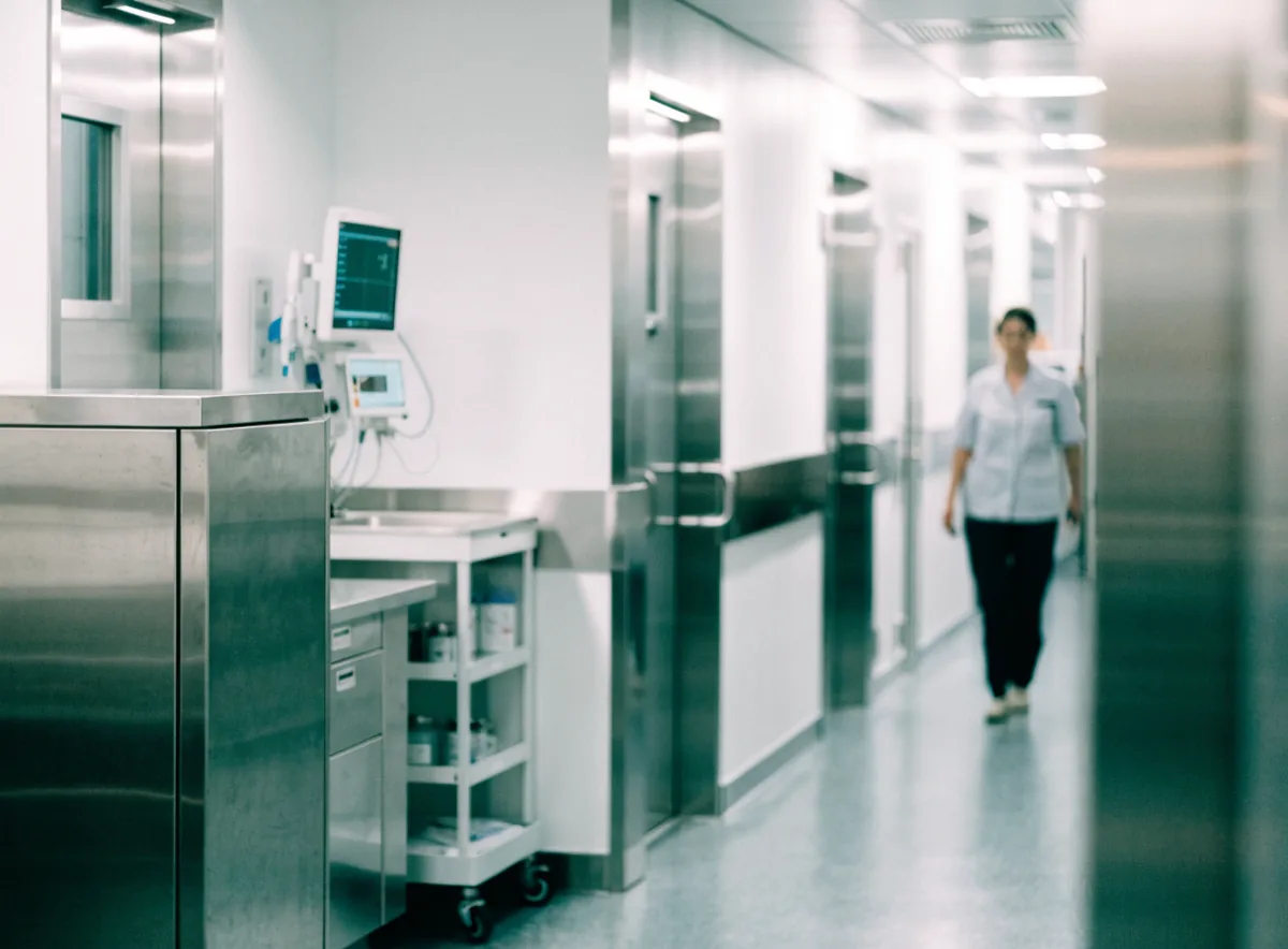 Pasillo de hospital con equipo médico y señalización de áreas