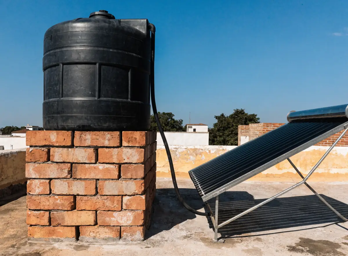 Tinaco elevado junto a un calentador solar en azotea